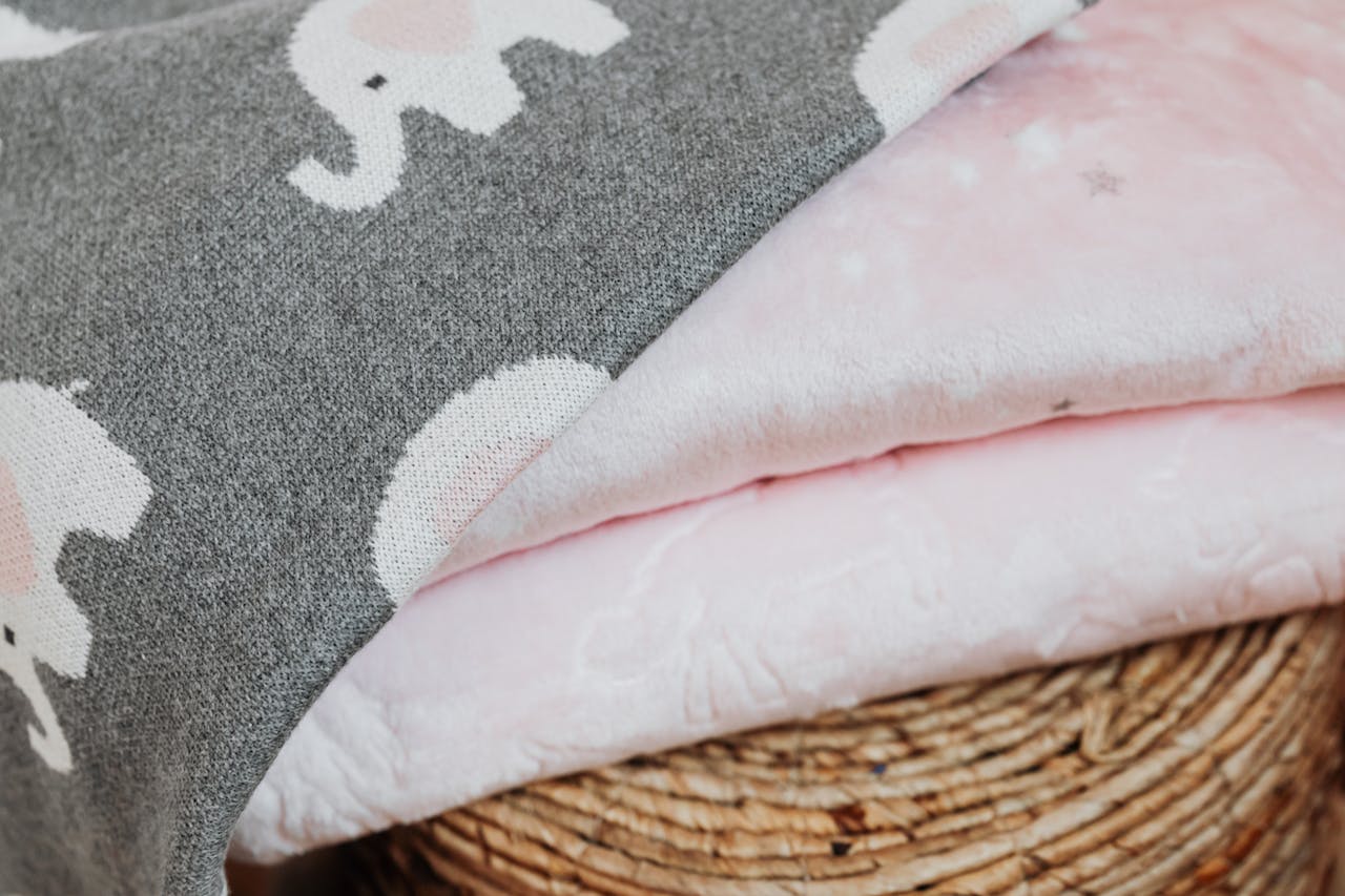 Close-up of elephant patterned blankets showcasing textured fabric and pastel colors.